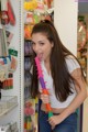 A young woman is holding a toy gun in a store.