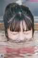 A woman with her eyes closed in the water.