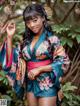 A woman in a blue and pink kimono posing for a picture.