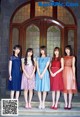 A group of young women standing in front of a door.